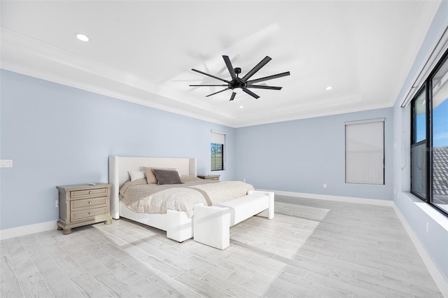 bedroom with baseboards, a raised ceiling, light wood-style floors, and crown molding