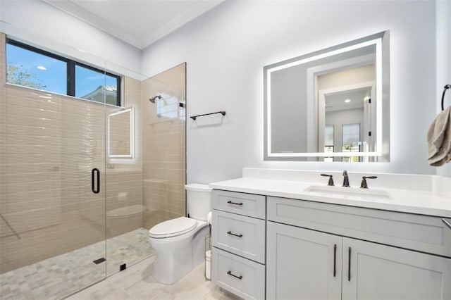 bathroom with vanity, toilet, a stall shower, and ornamental molding