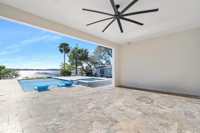 view of pool featuring a water view, a pool with connected hot tub, a ceiling fan, and a patio area