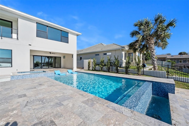 view of pool featuring a pool with connected hot tub, a ceiling fan, a patio, and fence