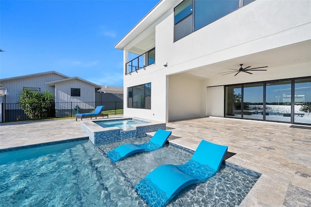 view of swimming pool featuring a ceiling fan, a patio area, fence, and a pool with connected hot tub