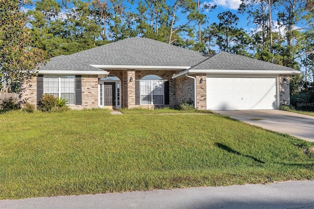 ranch-style home featuring brick siding, an attached garage, a shingled roof, and a front yard