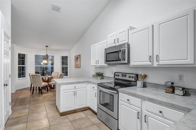 kitchen with visible vents, a peninsula, stainless steel appliances, vaulted ceiling, and white cabinetry