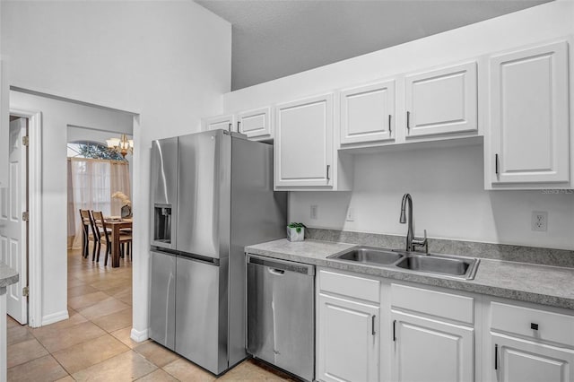 kitchen featuring a sink, stainless steel appliances, light countertops, and white cabinetry