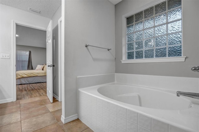 full bath featuring visible vents, baseboards, ensuite bath, a bath, and a textured ceiling