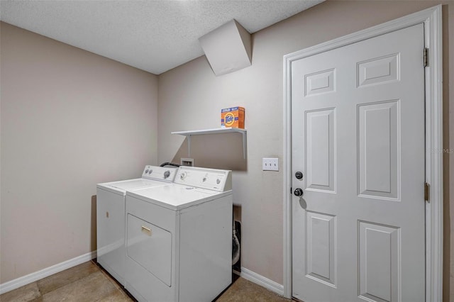 laundry room with washer and dryer, baseboards, a textured ceiling, and laundry area