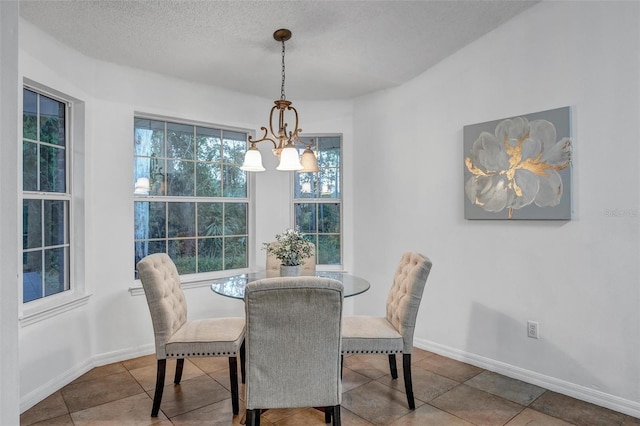 dining area with an inviting chandelier, baseboards, and a textured ceiling