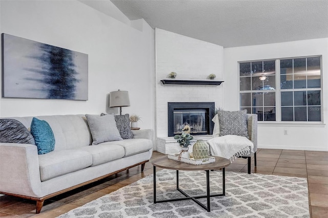 living room featuring vaulted ceiling, a brick fireplace, and a textured ceiling