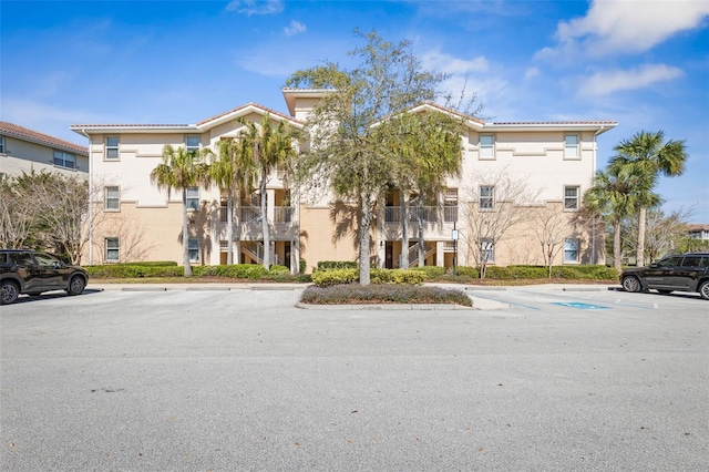 view of building exterior featuring stairway and uncovered parking