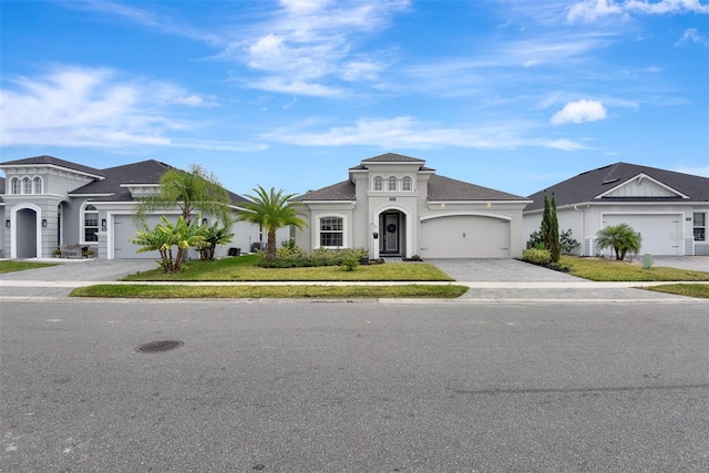 view of front of home featuring decorative driveway, a garage, and stucco siding