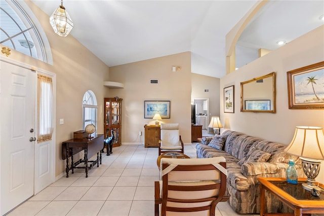 living room with visible vents, baseboards, high vaulted ceiling, and light tile patterned flooring