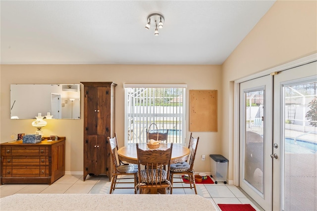 dining space featuring a wealth of natural light, light tile patterned floors, french doors, and lofted ceiling