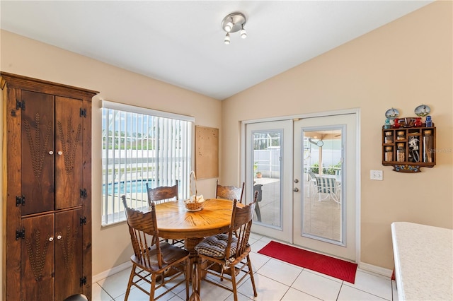 dining room with light tile patterned floors, french doors, baseboards, and lofted ceiling