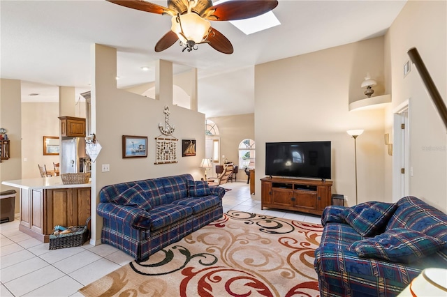 living area with light tile patterned floors, a ceiling fan, and vaulted ceiling