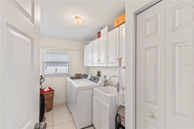 washroom with washer and dryer, cabinet space, and light tile patterned flooring