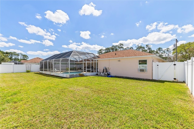 rear view of property with glass enclosure, a yard, a fenced backyard, and a gate