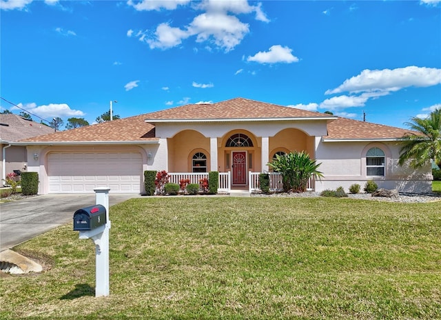 view of front of house with an attached garage, a porch, a front yard, stucco siding, and driveway