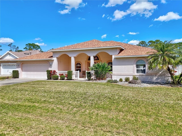 mediterranean / spanish home with stucco siding, driveway, a porch, an attached garage, and a front yard