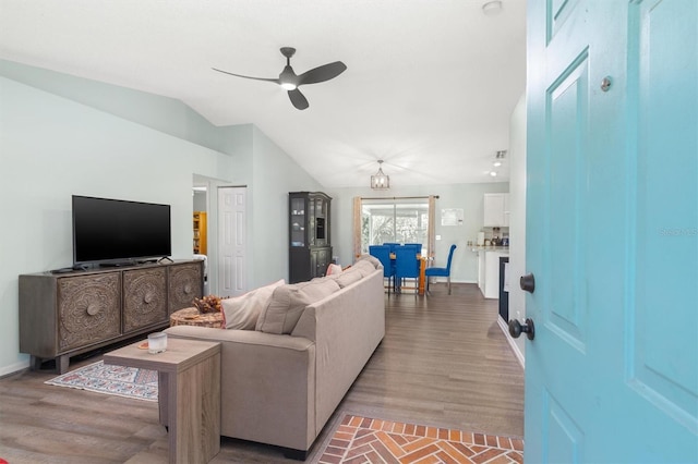 living room featuring lofted ceiling, wood finished floors, a ceiling fan, and baseboards