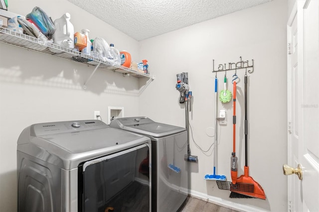 laundry area with laundry area, independent washer and dryer, and a textured ceiling