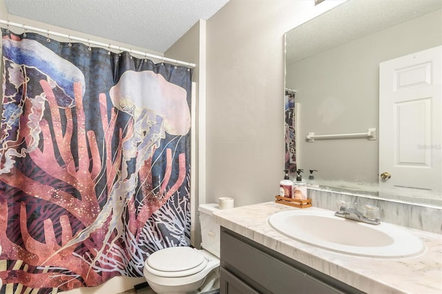 bathroom with vanity, curtained shower, toilet, and a textured ceiling