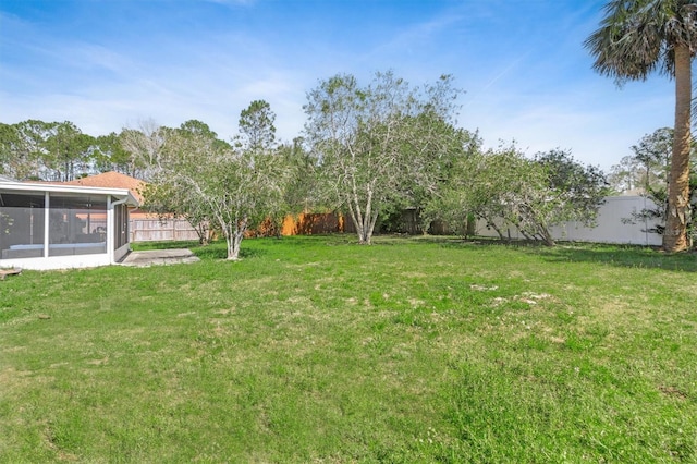 view of yard with a fenced backyard and a sunroom