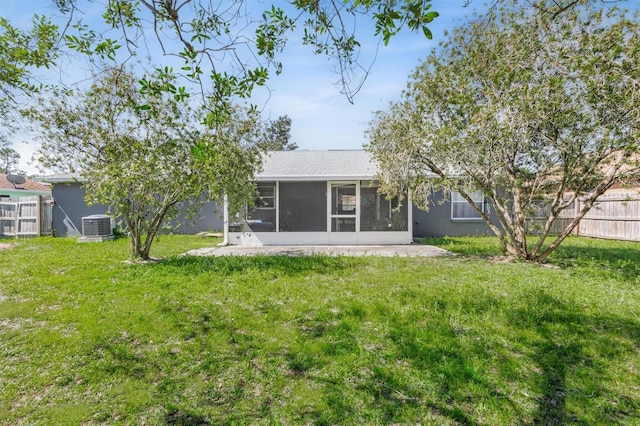 back of property with a yard, fence, central AC, and a sunroom