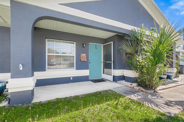 view of exterior entry with stucco siding