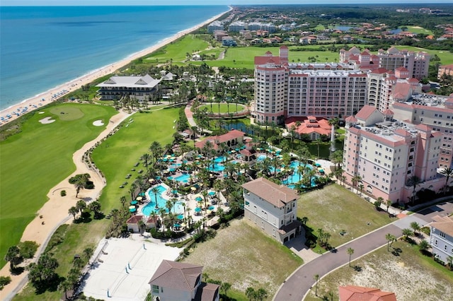 bird's eye view with a water view, view of golf course, a view of city, and a beach view