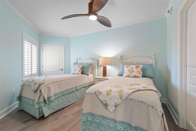 bedroom featuring ornamental molding, a ceiling fan, baseboards, and wood finished floors