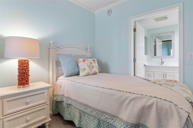 bedroom with visible vents, a sink, ensuite bath, and ornamental molding