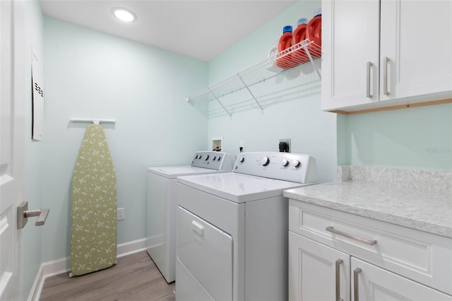 laundry area with baseboards, washer and clothes dryer, recessed lighting, light wood-style flooring, and cabinet space