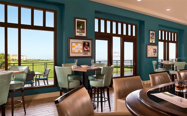 dining room featuring a high ceiling, recessed lighting, wood finished floors, and baseboards