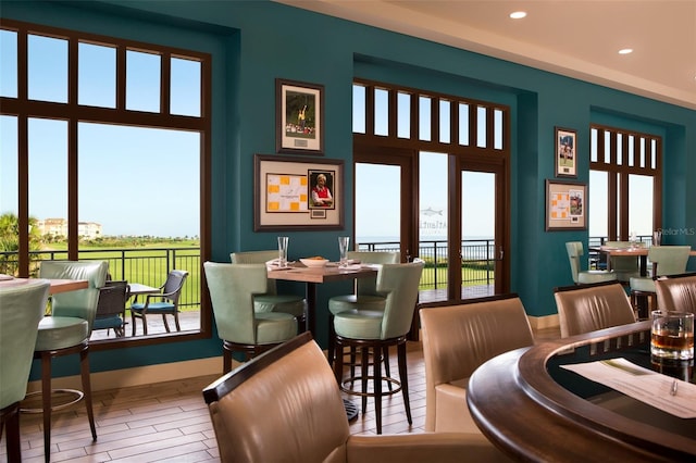 dining room featuring recessed lighting, a high ceiling, baseboards, and wood finished floors