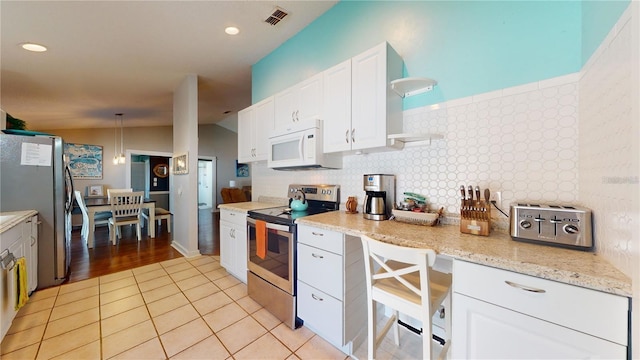 kitchen featuring visible vents, open shelves, white cabinetry, stainless steel appliances, and light tile patterned flooring