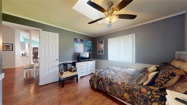 bedroom featuring a textured ceiling, a ceiling fan, and wood finished floors