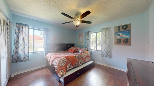 bedroom featuring multiple windows, baseboards, and wood finished floors