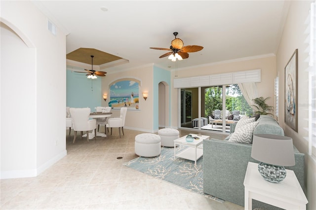 living room with light tile patterned floors, baseboards, arched walkways, and ornamental molding