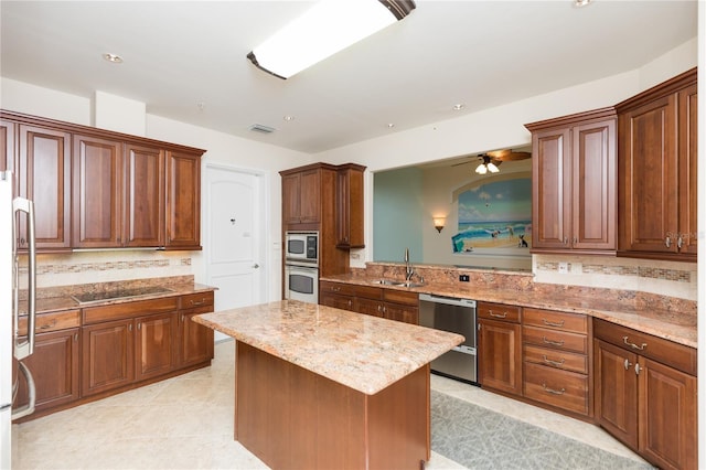 kitchen with visible vents, a sink, tasteful backsplash, a kitchen island, and appliances with stainless steel finishes