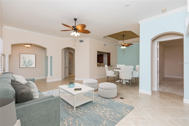 living room with a ceiling fan, baseboards, visible vents, arched walkways, and ornamental molding