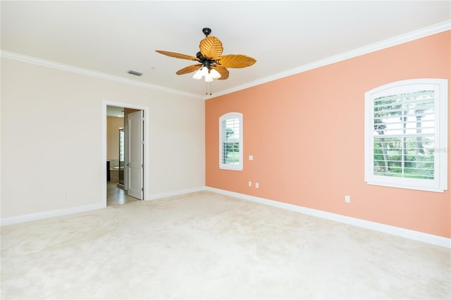 empty room with crown molding, light colored carpet, visible vents, and baseboards