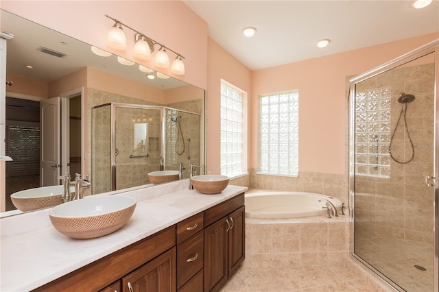 bathroom featuring a bath, visible vents, a shower stall, and a sink