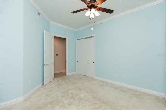 unfurnished bedroom featuring a closet, carpet, crown molding, baseboards, and ceiling fan