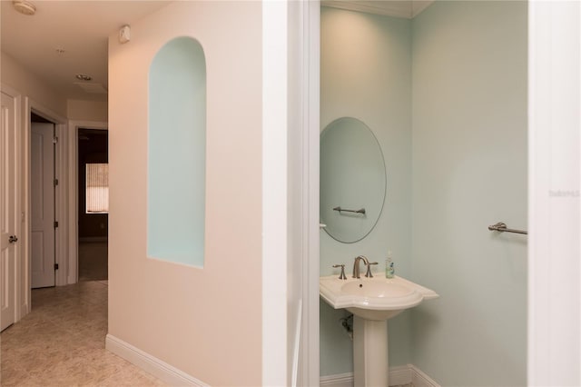 bathroom featuring baseboards and a sink