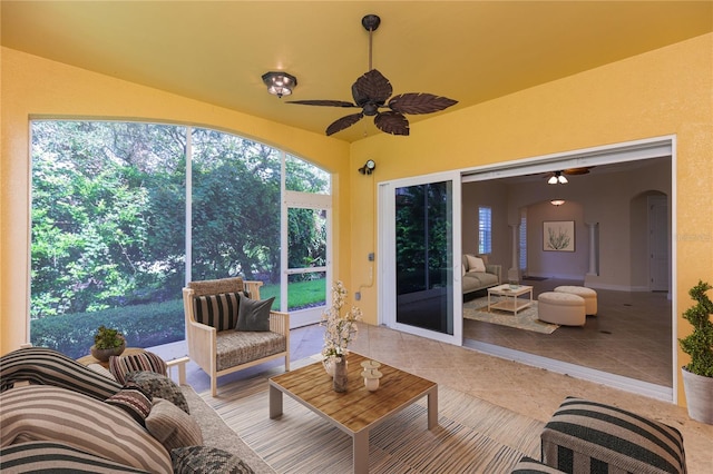 sunroom / solarium with arched walkways and ceiling fan