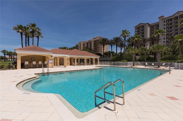 pool with a patio and fence