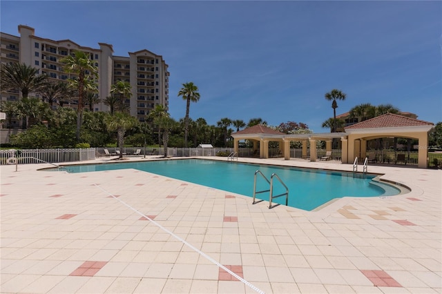 community pool featuring a gazebo, a patio, and fence