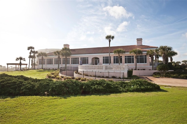 exterior space with a lawn, a tiled roof, a chimney, and stucco siding