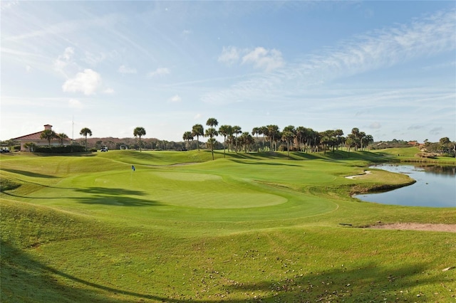 view of property's community featuring a water view, a yard, and view of golf course