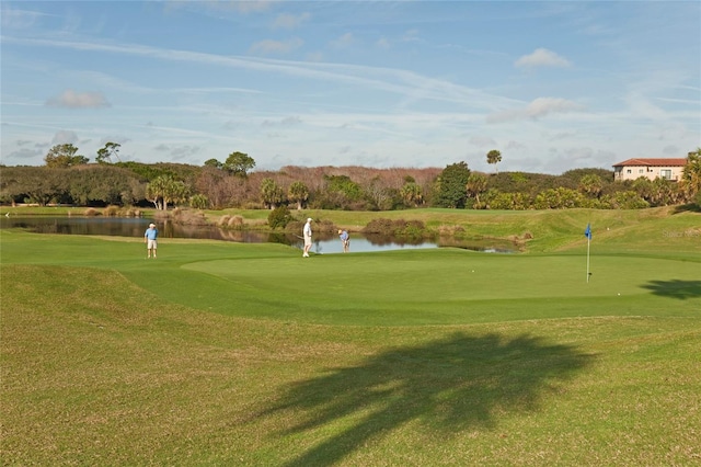 view of home's community featuring a water view, a lawn, and view of golf course